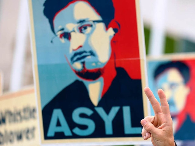 Auf einem Plakat fordern  Demonstranten  Asyl fr Snowden.   | Foto: dpa