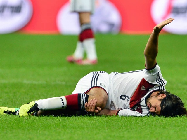 Sami Khedira liegt nach einem Zusammen...Rasen des Mailnder San Siro-Stadions.  | Foto: AFP