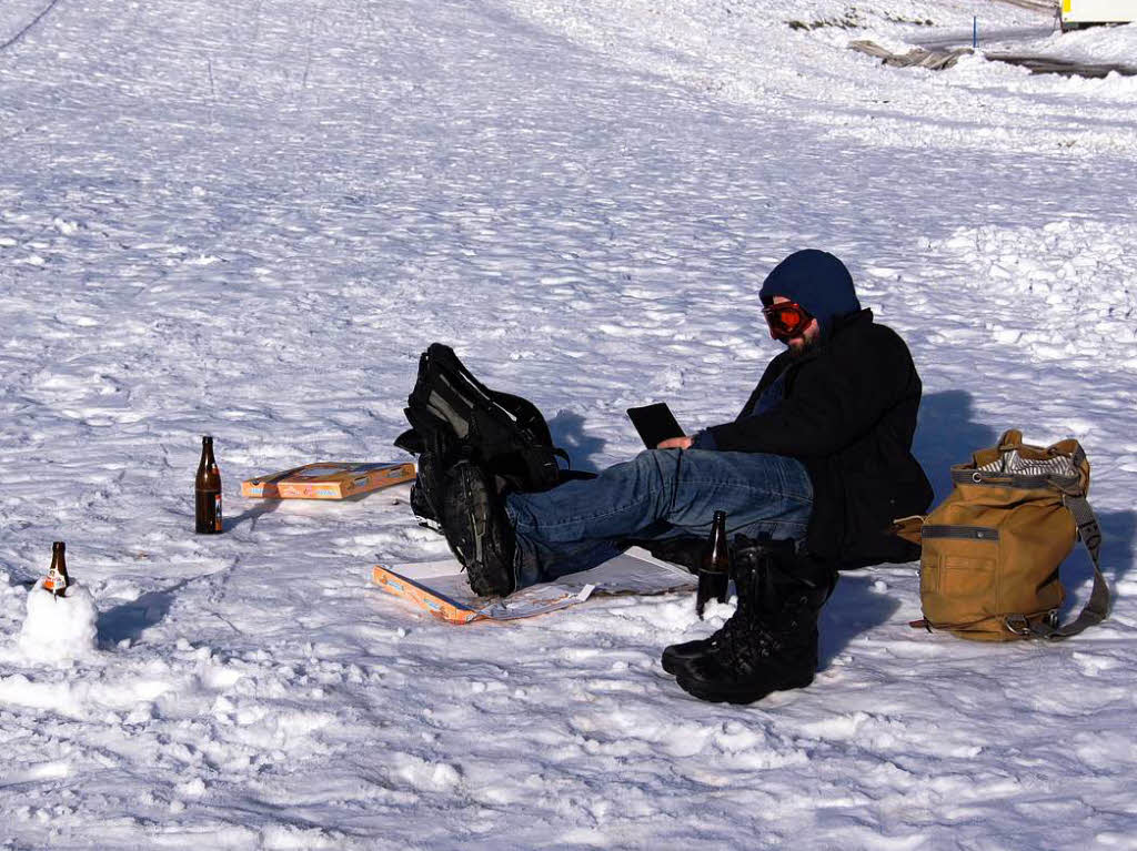 Picknick im Schnee: Dieser junge Mann liest ganz gemtlich ein Buch am Rande der Piste.