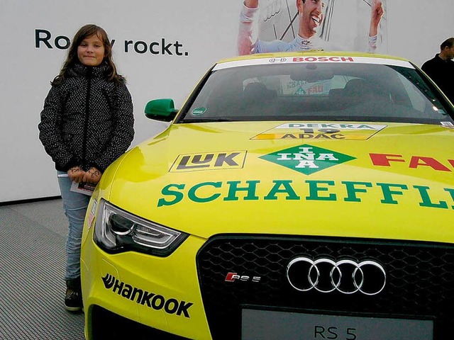 DTM-Fan Lea Kuhn posiert neben einem Rennwagen.   | Foto: Privat