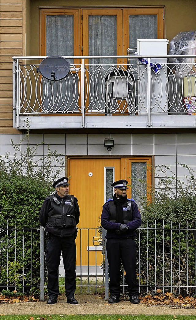 Polizisten vor einem Haus, in dem Kollegen ermitteln.   | Foto: afp