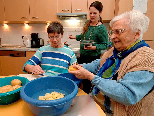 Senioren kochen gemeinsam mit einer He...ner Wohngemeinschaft ihr Mittagessen.   | Foto: DPA