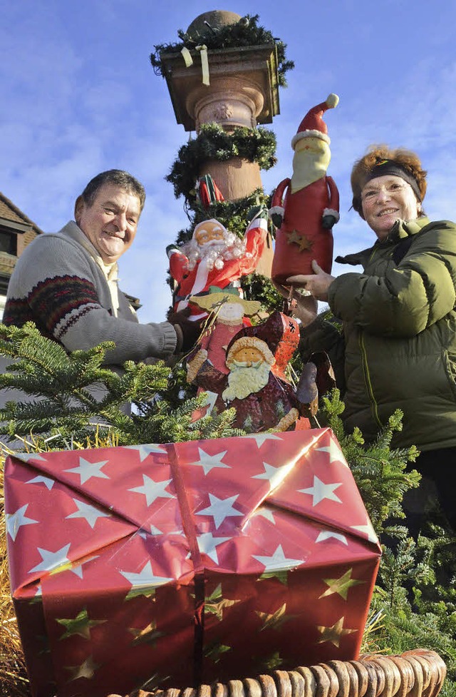 Brigitte Zentis und Oscar Guidone schm...ktbrunnen mit weihnachtlichen Symbolen  | Foto: Sylvia-Karina Jahn