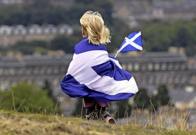 Ein kleines Mdchen in die schottische Fahne gehllt   | Foto: AFP