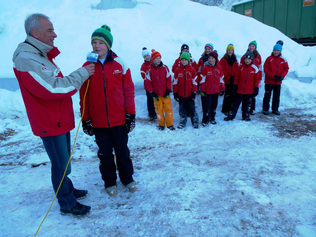 Weltcup-Pressesprecher Roland Weis interviewt die Fahnenfahrer des Skiclubs Neustadt, die beim Weltcup als Attraktion den steilen Aufsprunghgel hinabfahren werden.