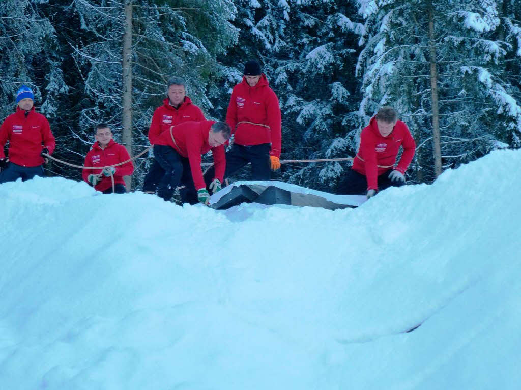 Wie bei der Geburtstagstorte: Das Schanzenteam schneidet die Folie auf, die den Gletscher den Sommer ber vor der Witterung schtzte.