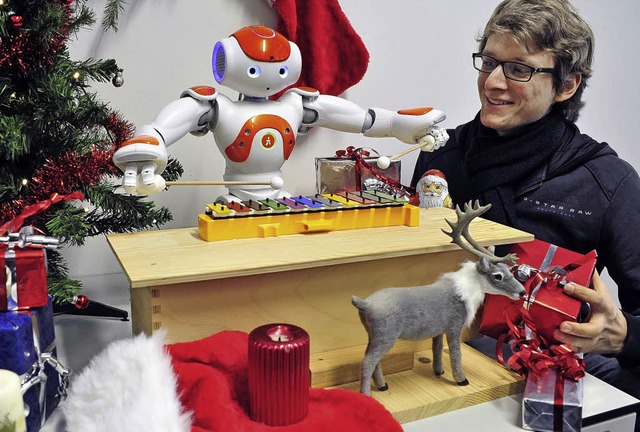 Frhliche Weihnacht: Roboter Ra (links...0;, Informatiker Daniel Maier hrt zu.  | Foto: Thomas Kunz