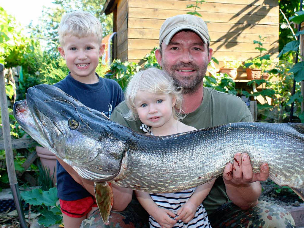 Ein dicker Fang – Angler Christian Kuhn mit de,m elf Kilogramm schweren Hecht und seinen stolzen Kindern Finn und Marlene