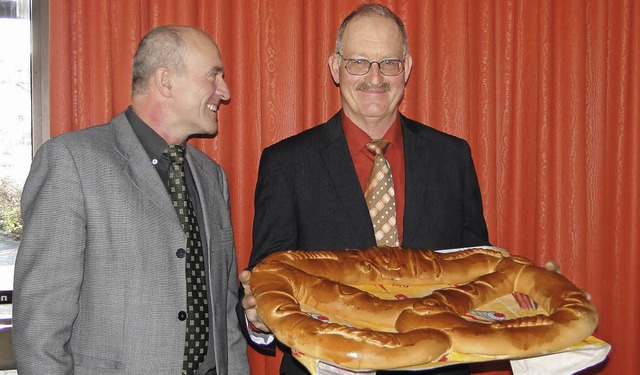 Der Bischoffinger Ortsvorsteher Jost G...er Otto Schneider eine Neujahrsbrezel.  | Foto: Elisabeth Saller