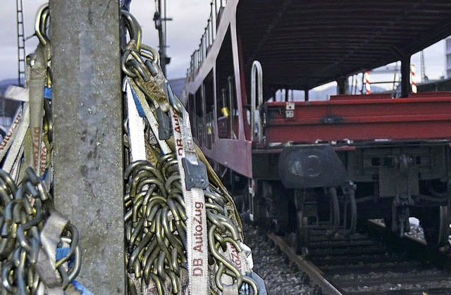Mit Eisenhaken werden die Autos auf dem Zug befestigt.   | Foto: Trenz