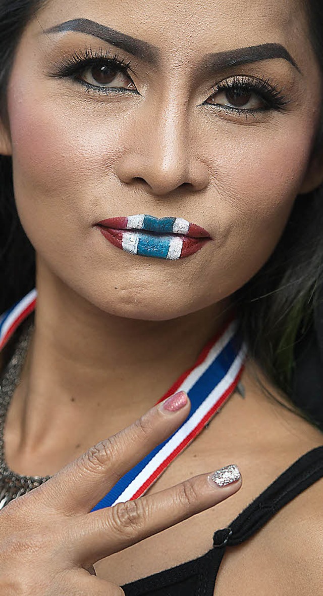 Eine Demonstrantin hat die Lippen in den Farben Thailands bemalt.   | Foto: AFP
