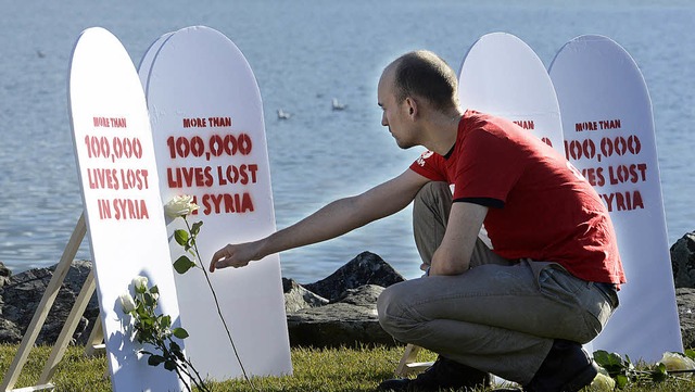 &#8222;Mehr als 100000 verlorene Leben...teht auf den Plakaten am Genfer See.    | Foto: AFP