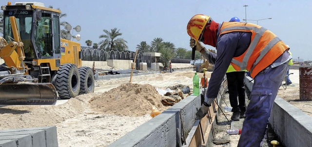 Arbeiter auf einer Straenbaustelle fr die WM in Katar   | Foto: DPA