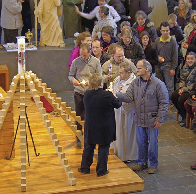 Die Teilnehmer der kleinen Prozession ...und platzierten sie auf dem Kerzenbaum  | Foto: Rolf Reimann