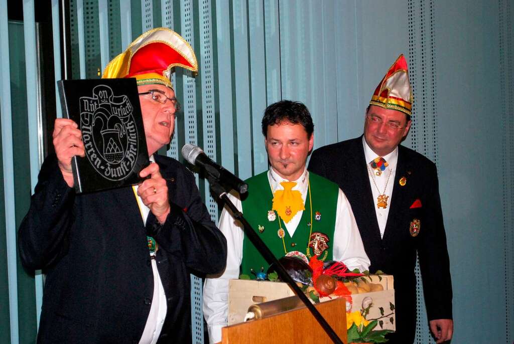 Zunftmeister Wilfried Meyer (links) und Andreas Dewaldt (rechts) berreichten  Zunftmeister  Trogus das Wappen der Breisacher Narrenzunft.