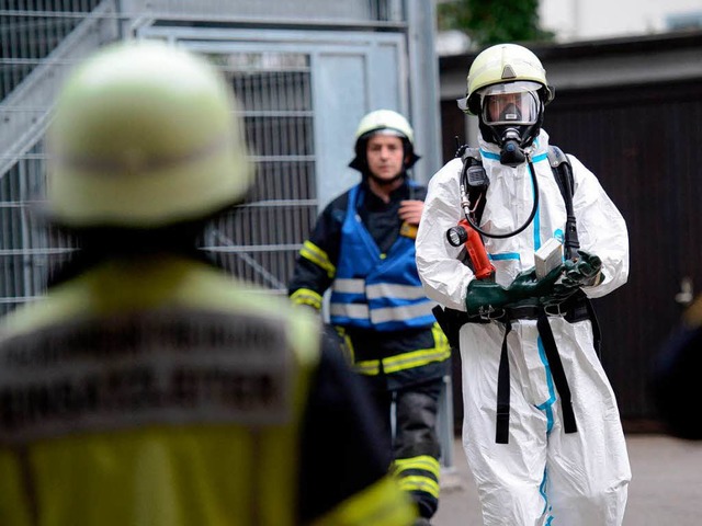 Ein Feuerwehrmann in Schutzkleidung tr...rtiert die rtselhafte Postsendung ab.  | Foto: Patrick Seeger