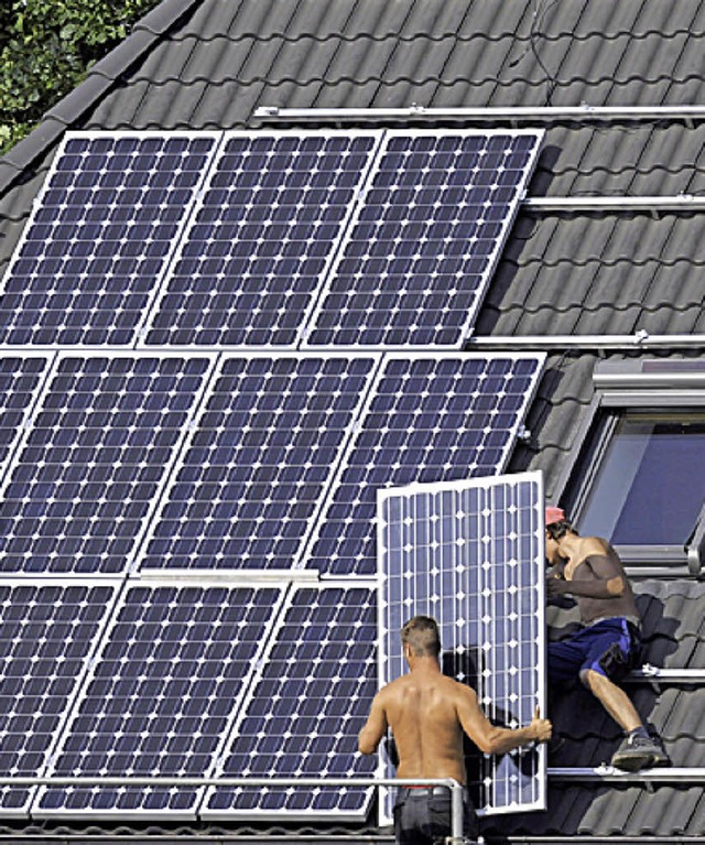 Arbeiter installieren eine Photovoltaikanlage.  | Foto: dpa Deutsche Presse-Agentur