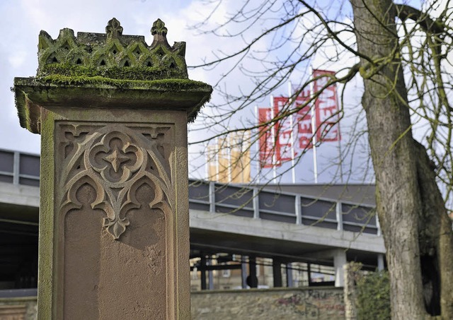 Kontrast pur: Ein Sandstein-Grabmal au...f dem Areal Merk mit ihrer Beflaggung.  | Foto: KLaus Fehrenbach