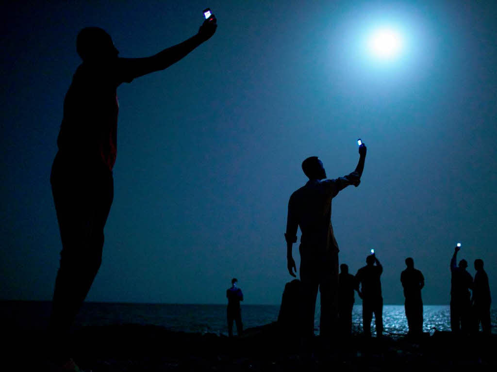 Somalische Migranten in Dschibuti suchen nach einem Signal, um ihre Familien zu erreichen: John Stanmeyer (USA) hat mit „Signal“ den Wettbewerb gewonnen. Somalische Migranten in Dschibuti suchen nach einem Signal, um ihre Familien zu erreichen: John Stanmeyer (USA) hat mit „Signal“ den Wettbewerb gewonnen.