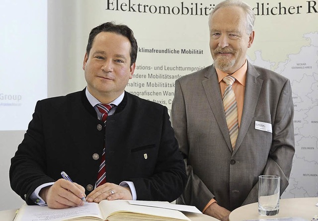 Minister Alexander Bonde (links) verew...tlinger schaut ihm ber die Schulter.   | Foto: S. Wolfrum