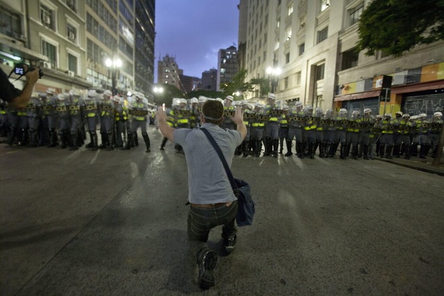 Ein Demonstrant signalisiert Gewaltfre... angesichts der nahenden Polizeikette.  | Foto: dpa