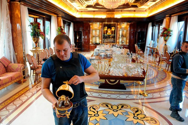 Prsident Janukowitsch residierte wie ...Aktivist zeigt das kostbare Inventar.   | Foto: dpa/AFP
