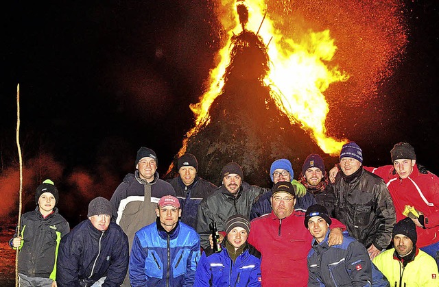 Das Aufbauteam der Narrenzunft Tannenzpfle vor dem brennenden Fastnachtsfeuer.   | Foto: Stefan Pichler