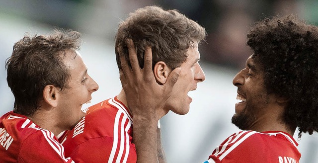 Entrcktes Trio: Rafinha, Thomas Mlle...ante feiern den 6:1-Sieg in Wolfsburg.  | Foto: afp