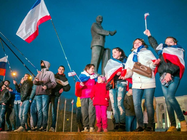 Menschen mit Russlandfahnen jubeln am ...Leninplatz in Simferopol auf der Krim.  | Foto: dpa