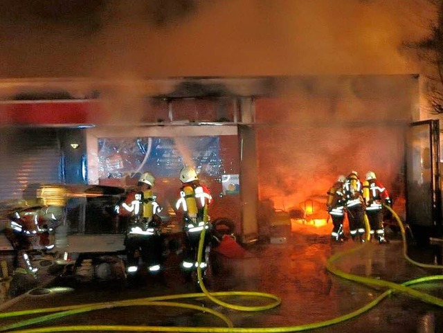 Feuerwehrleute halten das Feuer in Sch... das bergreifen auf die Tankstelle.    | Foto: Utke