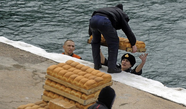 Russische Matrosen entladen in Sewastopol Brot von einem Schiff.   | Foto: AFP