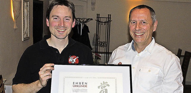 Ehrenurkunde fr Jens Brillault  von Peter Voll (rechts).   | Foto: Privat