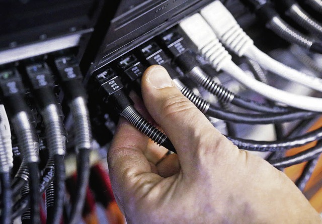 Verbindung zum Internet gekappt: Ein Mann zieht an einem LAN-Kabel.   | Foto: dpa