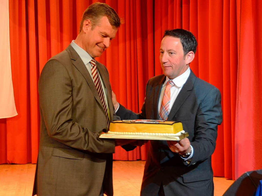 Brgermeisterstellvertreter Jrg Leber (rechts) berreicht Oliver Rein eine Torte als Wahlgeschenk.