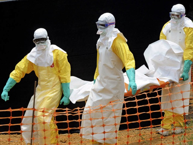Schutz ist berlebenswichtig: rzte oh...eren den Leichnam eines Ebola-Opfers.   | Foto: dpa