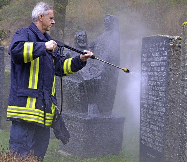 Mit dem Hochdruckreiniger  wird das Ehrenmal auf dem Friedhof gereinigt.   | Foto: paul berger