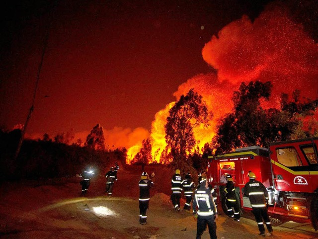 Feuerwehrleute kmpfen gegen den vom Wind neu entfachten Brand in Valparaso.   | Foto: AFP