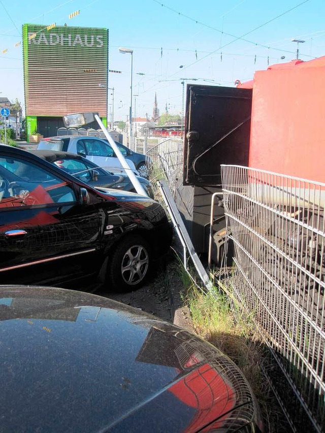 Die Rangierlok hat einen Metallzaun durchbrochen und drei Autos beschdigt.  | Foto: Polizei