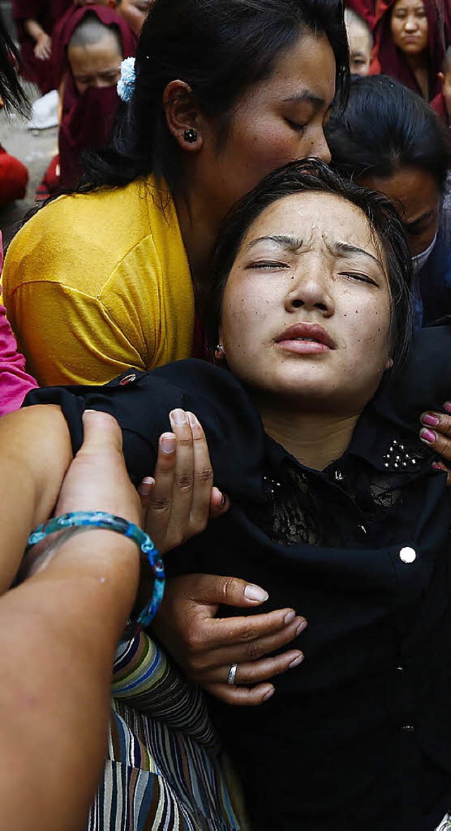 Die Tochter eines verunglckten Sherpas kollabiert auf der Trauerfeier.   | Foto: dpa