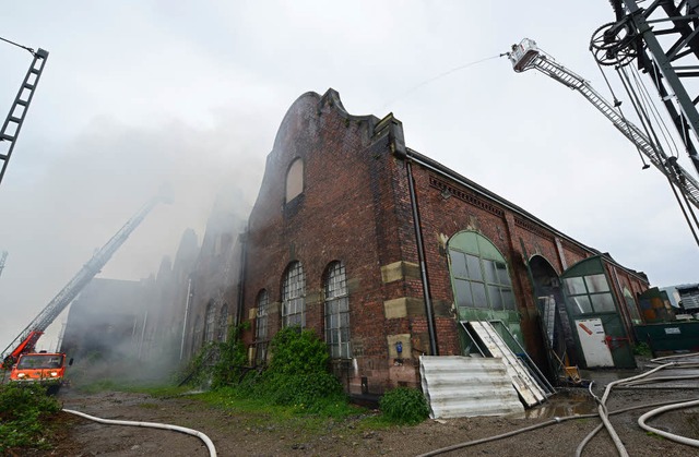 Von der Drehleiter aus bekmpfen Feuer... den Brand auf dem Dach der Lokhalle.   | Foto: Patrick Seeger