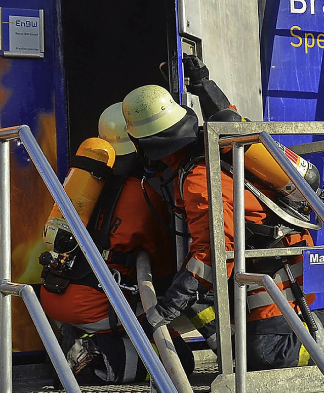 Zwei Rheinfelder Feuerwehrmnner ffnen die Tr der mobilen Brandschutzanlage   | Foto: Peter Gerigk