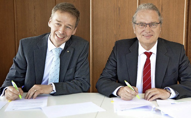 Achim Geigle (Energiedienst, links) un...schreiben den Vertrag fr das Projekt.  | Foto: Ingrid Bhm-Jacob
