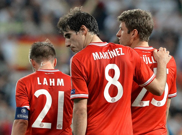 Die Bayern-Spieler Philipp Lahm, Javi ...ller verlassen enttuscht den Platz.   | Foto: dpa