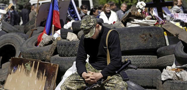 Ein prorussischer Kmpfer ruht sich in...r fr einen getteten Kameraden statt.  | Foto: dpa