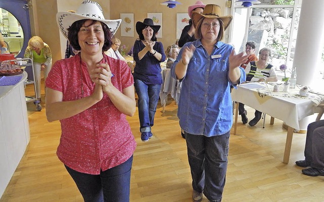 Einige Mitarbeiterinnen mit Cowboyhut ...nen flotten  Line-Dance aufs Parkett.   | Foto: Claudia Gempp