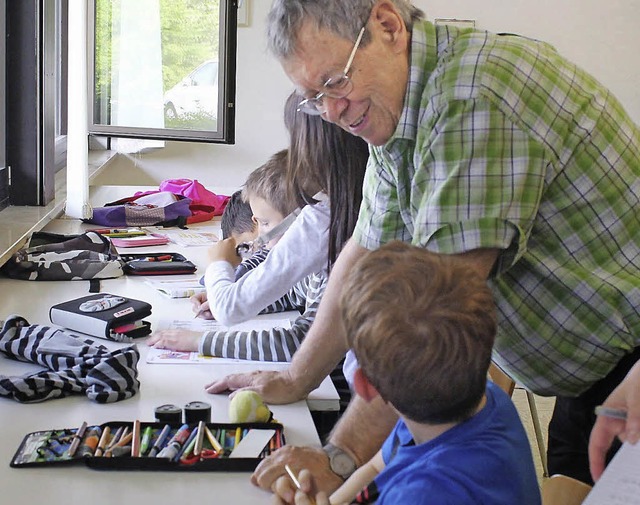 Dirk Feltes und andere Ehrenamtliche h...ndschulkindern  bei den Hausaufgaben.   | Foto: Albert Greiner