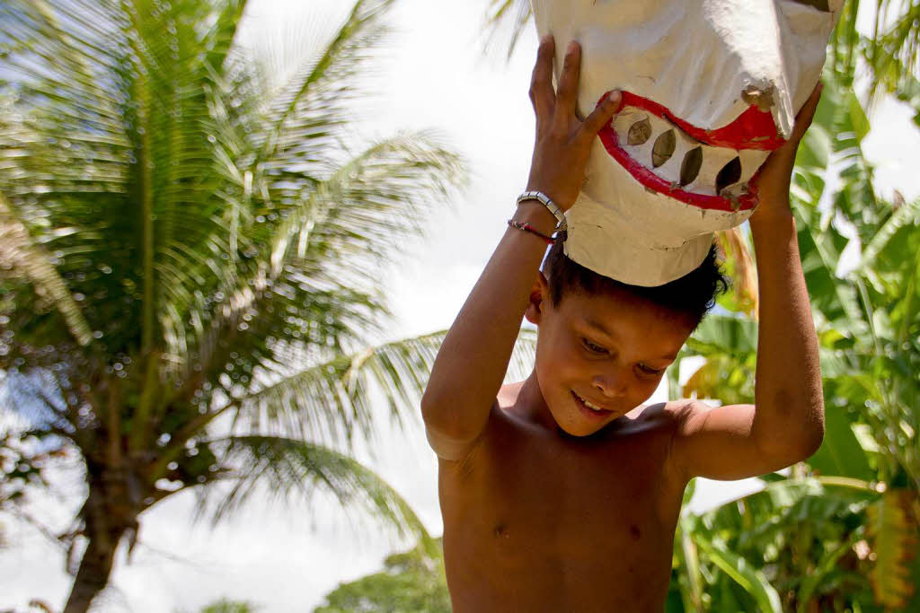 Ein Junge aus der Elendssiedlung Tururu spielt mit einer Brenmaske. Im brasilianischen Recife ist diese Verkleidung beim Karneval sehr beliebt.