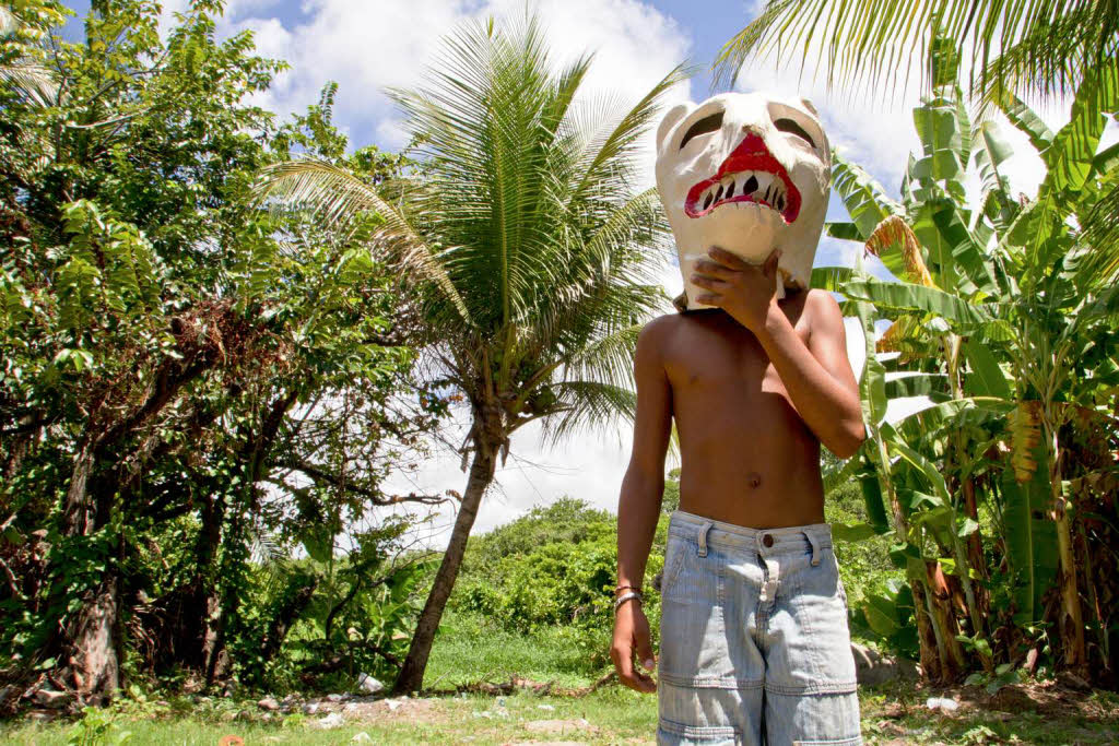 Ein Junge in Tururu bei Recife macht sich mit einer Brenmaske fr den Karneval warm.