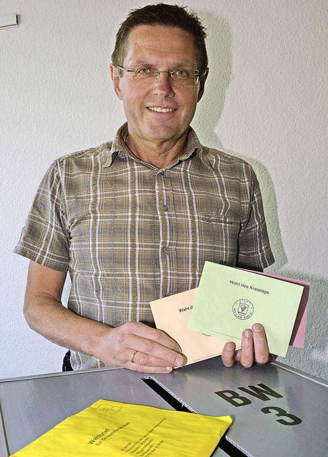 Wahlleiter Jrgen Schopferer hlt die ...r gelbe Wahlbrief eines Briefwhlers.   | Foto: Lauber