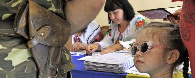 Stimmabgabe unter Schutz des Militrs:...Sonntag in einem Wahllokal in Lemberg   | Foto: dpa